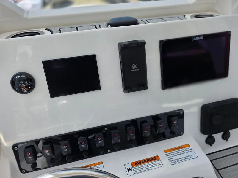 Slide: The Image of The image shows the dashboard of a Yamaha 222 FSH Sport E boat with multiple screens and switches. - 21