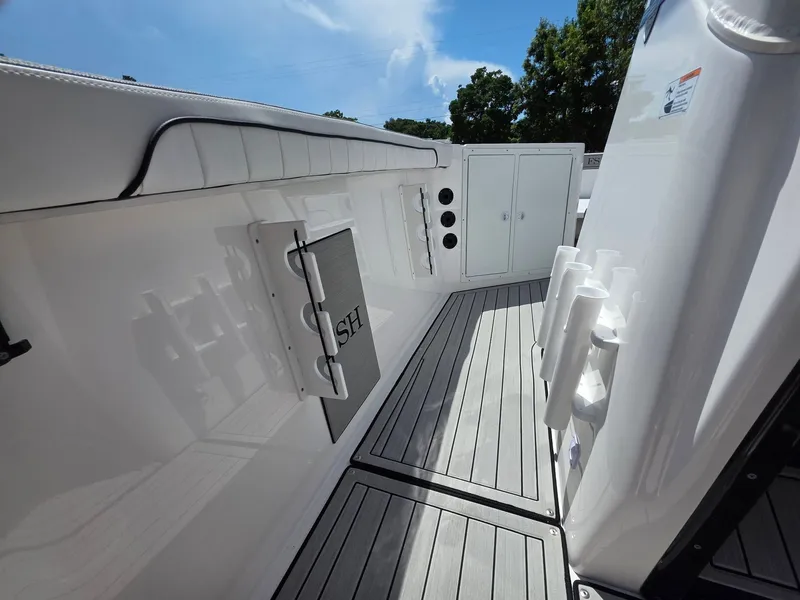 Slide: The Image of The image shows the deck of a Yamaha 222 FSH Sport E boat with storage and rod holders. - 18