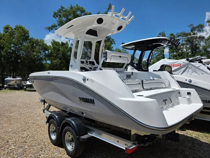 Slide: The Image of Yamaha 222 FSH Sport E 2026 on a trailer, surrounded by trees and other boats. - 1