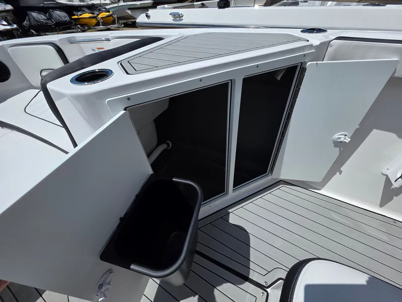 Slide: The Image of The image shows the storage area of a 2026 Yamaha 222 FSH Sport E boat with open doors. - 23