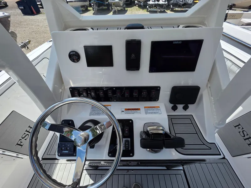 Slide: The Image of The image shows the helm of a Yamaha 222 FSH Sport E boat with modern controls. - 20