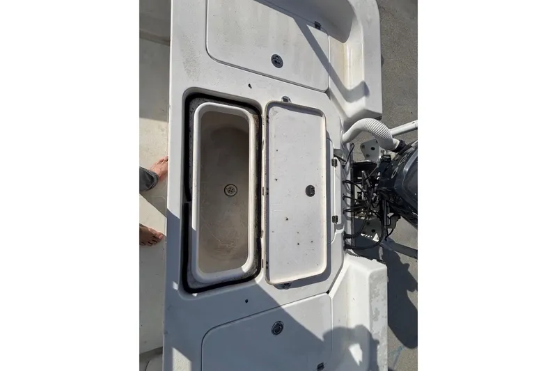 Slide: The Image of 2004 Palmetto 22 boat deck with storage compartments and engine view. - 12