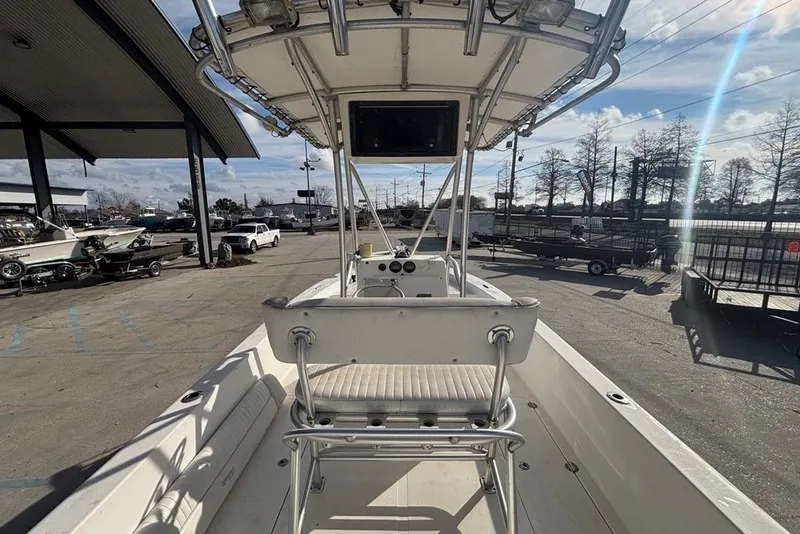 Slide: The Image of 2004 Palmetto 22 boat interior with seating and console, parked outdoors. - 15