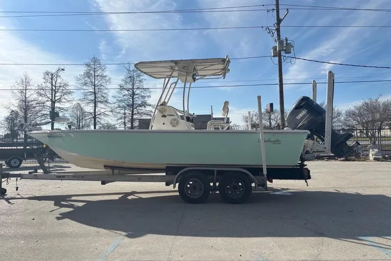 Slide: The Image of 2004 Palmetto 22 boat on trailer, parked outdoors under clear sky. - 6