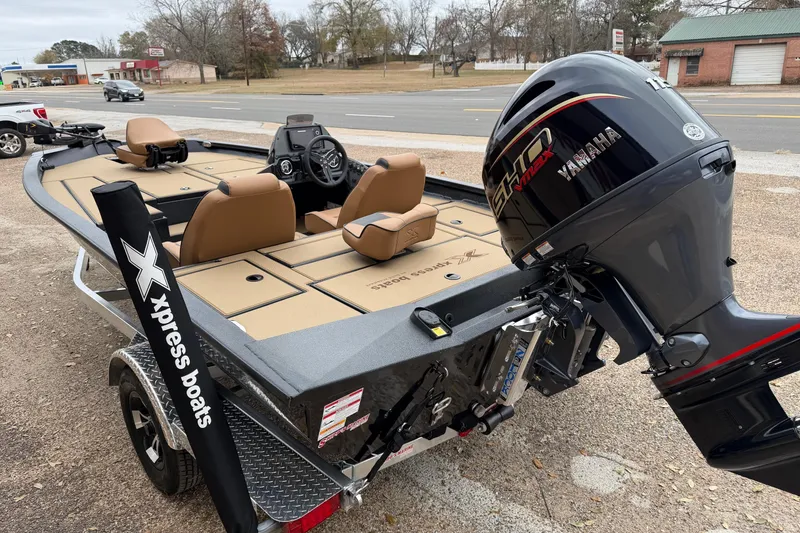 Slide: The Image of 2026 Xpress H18 boat with Yamaha engine, parked on a trailer near a road. - 6