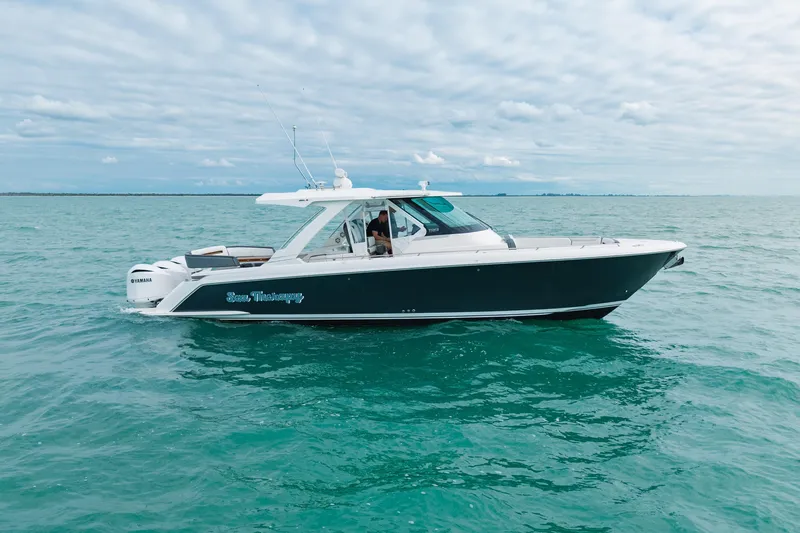 The Image of 2020 Tiara Sport 38 LS boat cruising on open water under cloudy sky. - 0