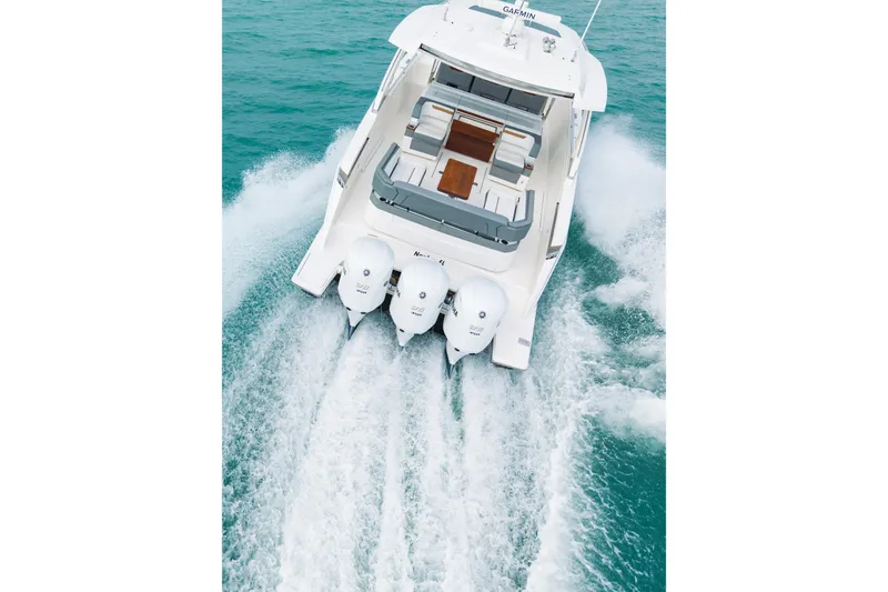 Slide: The Image of 2020 Tiara Sport 38 LS boat cruising on turquoise water, rear view. - 10