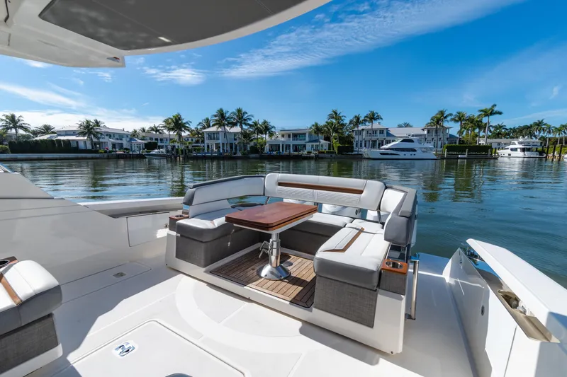 Slide: The Image of 2020 Tiara Sport 38 LS yacht with luxurious seating, docked near waterfront homes. - 13