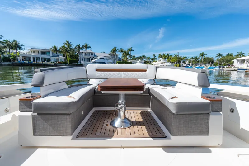 Slide: The Image of 2020 Tiara Sport 38 LS yacht interior with elegant seating and table, docked by waterfront homes. - 14