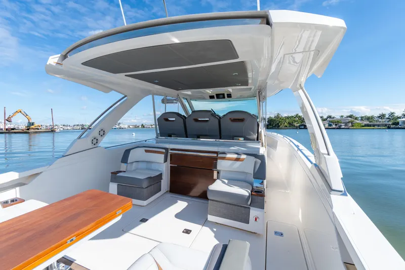 Slide: The Image of 2020 Tiara Sport 38 LS luxury boat interior with seating, docked by calm waters. - 16