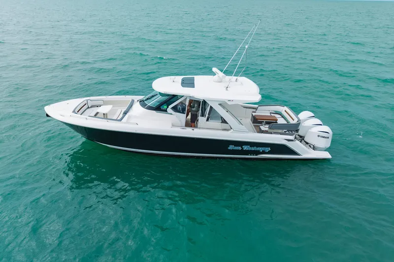 Slide: The Image of 2020 Tiara Sport 38 LS boat cruising on clear blue water. - 3