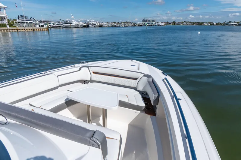 Slide: The Image of 2020 Tiara Sport 38 LS boat with seating area and table on calm water. - 31