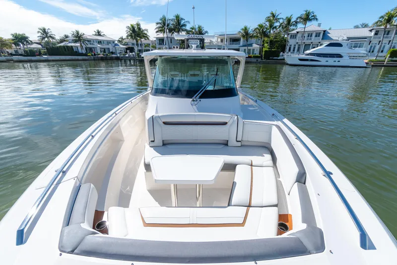 Slide: The Image of 2020 Tiara Sport 38 LS boat with luxurious seating, docked near waterfront homes. - 32