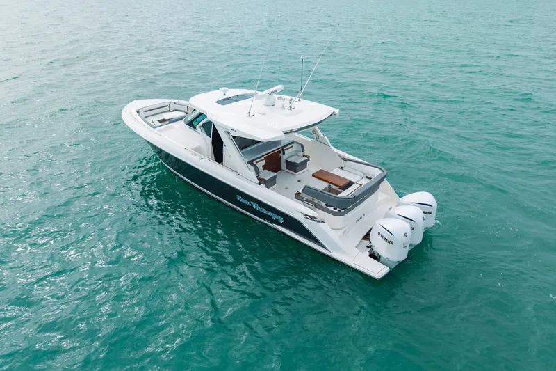 Slide: The Image of 2020 Tiara Sport 38 LS boat on turquoise water, featuring triple Yamaha engines. - 4