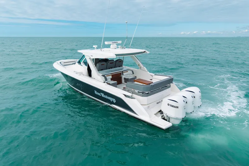 Slide: The Image of 2020 Tiara Sport 38 LS boat cruising on open turquoise waters. - 6