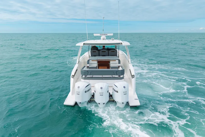 Slide: The Image of 2020 Tiara Sport 38 LS boat cruising on open sea with triple Yamaha engines. - 7
