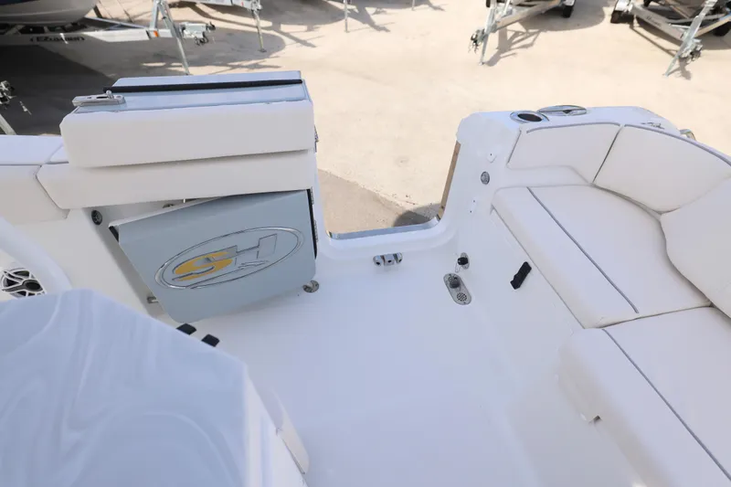 Slide: The Image of 2026 Sea Hunt Ultra 265 SE boat interior with white seating and storage compartment. - 10