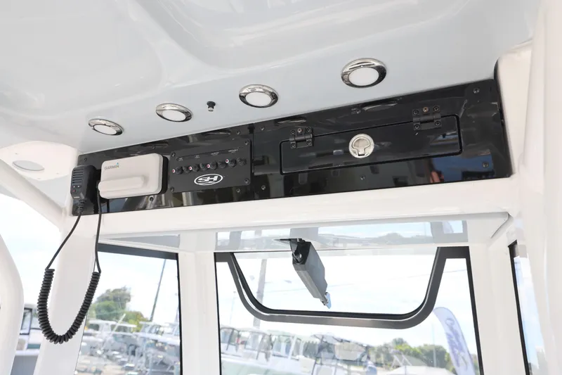 Slide: The Image of 2026 Sea Hunt Ultra 265 SE boat console with Garmin equipment and storage compartment. - 13