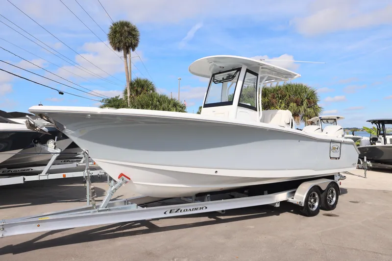 Slide: The Image of 2026 Sea Hunt Ultra 265 SE boat on trailer, displayed outdoors under blue sky. - 29