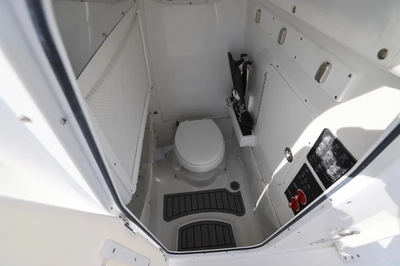 Slide: The Image of 2026 Sea Hunt Ultra 265 SE boat interior with compact marine toilet and control panel. - 7