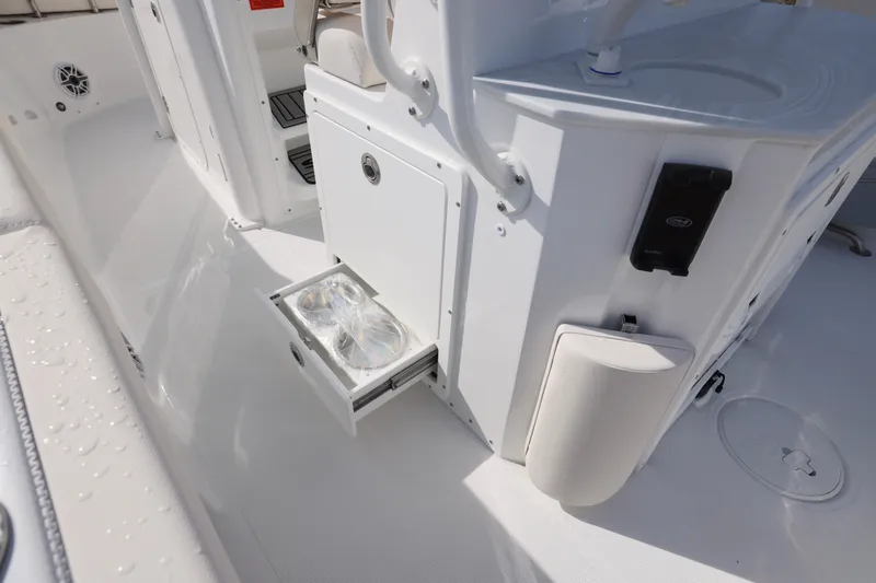 Slide: The Image of 2026 Sea Hunt Ultra 265 SE boat interior with open storage drawer and cup holders. - 9