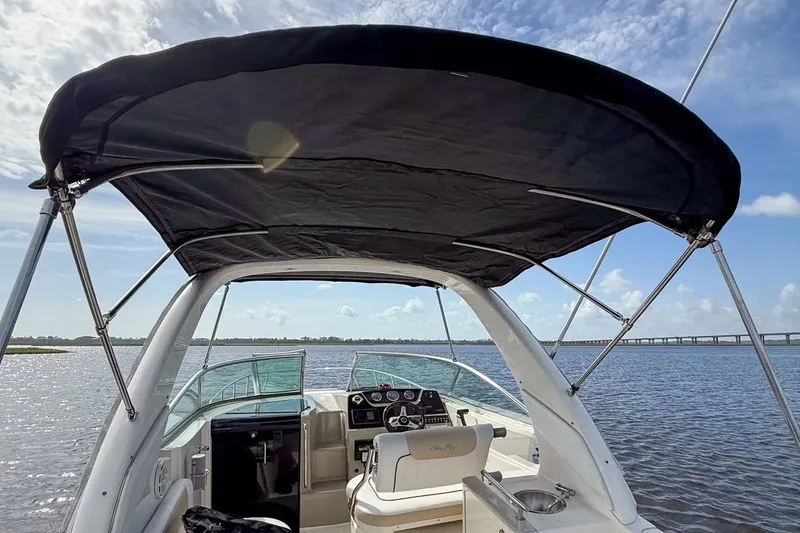 Slide: The Image of 2010 Sea Ray Sundancer 260 boat interior with canopy, steering console, and water view. - 15