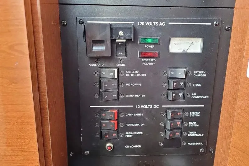 Slide: The Image of Control panel of a 2010 Sea Ray Sundancer 260 boat, featuring AC and DC switches. - 16