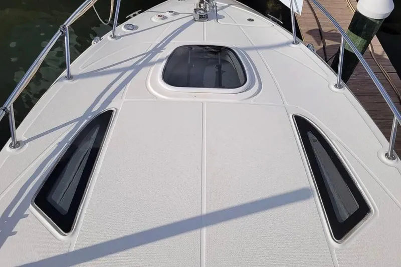 Slide: The Image of 2010 Sea Ray Sundancer 260 boat deck with hatch and railings, docked at marina. - 25