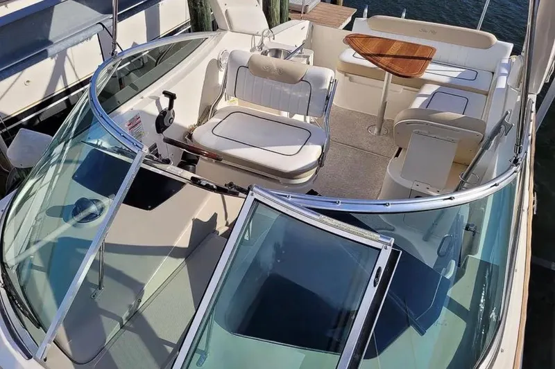 Slide: The Image of 2010 Sea Ray Sundancer 260 boat interior with seating and wooden table. - 27
