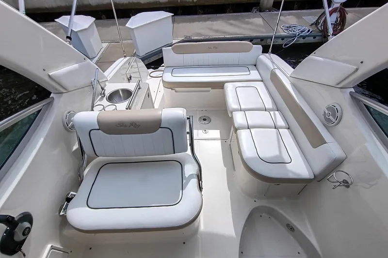 Slide: The Image of 2010 Sea Ray Sundancer 260 boat interior with white seating and cup holders. - 28
