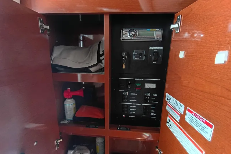 Slide: The Image of 2010 Sea Ray Sundancer 260 interior cabinet with control panel and storage items. - 40