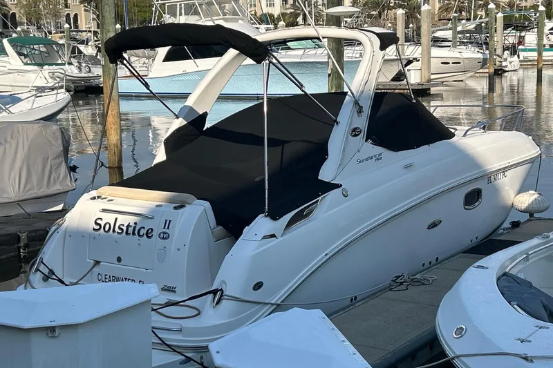 Slide: The Image of 2010 Sea Ray Sundancer 260 boat interior with white seating and open storage compartment. - 48