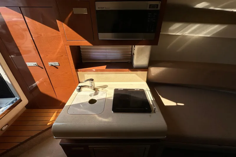 Slide: The Image of Storage compartment on a 2010 Sea Ray Sundancer 260 boat with cleaning supplies and stickers. - 62