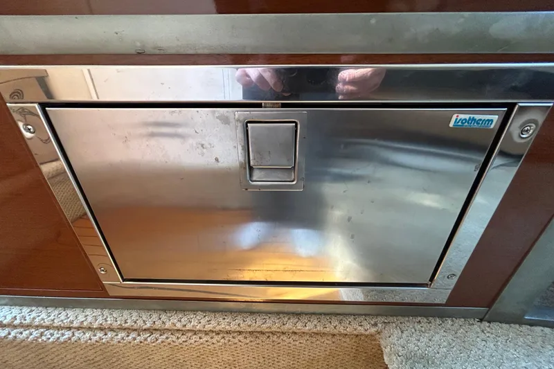 Slide: The Image of Storage compartment on a 2010 Sea Ray Sundancer 260 with cleaning supplies and fire extinguishers. - 63