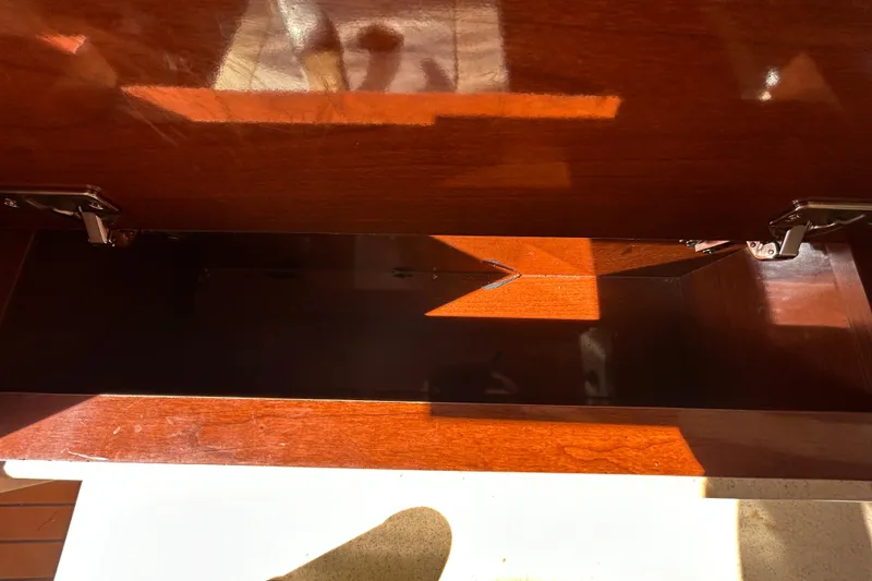 Slide: The Image of Storage compartment of a 2010 Sea Ray Sundancer 260 boat, showing a 12V outlet. - 74