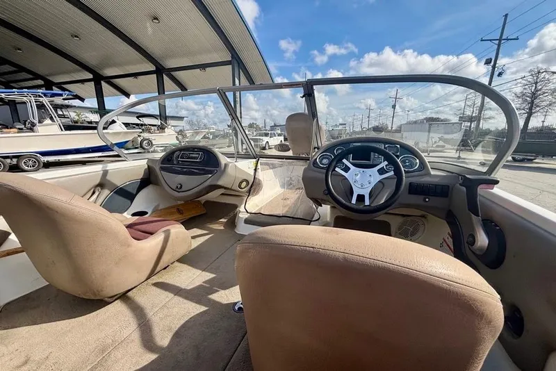 Slide: The Image of 2008 Ranger 180 Reata boat interior with steering wheel and dashboard under a sunny sky. - 11