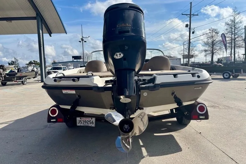 Slide: The Image of 2008 Ranger 180 Reata boat with outboard motor, parked outdoors on a sunny day. - 4