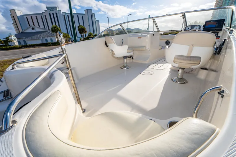 Slide: The Image of 2008 Wellcraft 180 Sportsman boat interior with seating and controls, near a hotel. - 12
