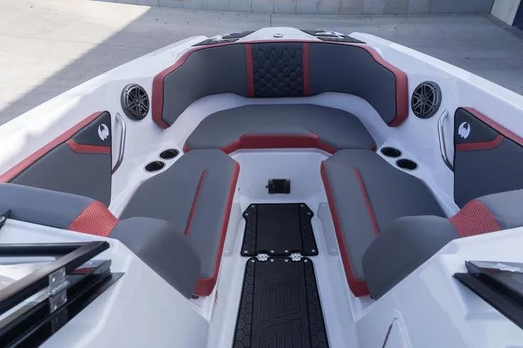 Slide: The Image of 2026 Scarab 255 LX Wake boat interior with gray and red seating, cup holders, and speakers. - 21