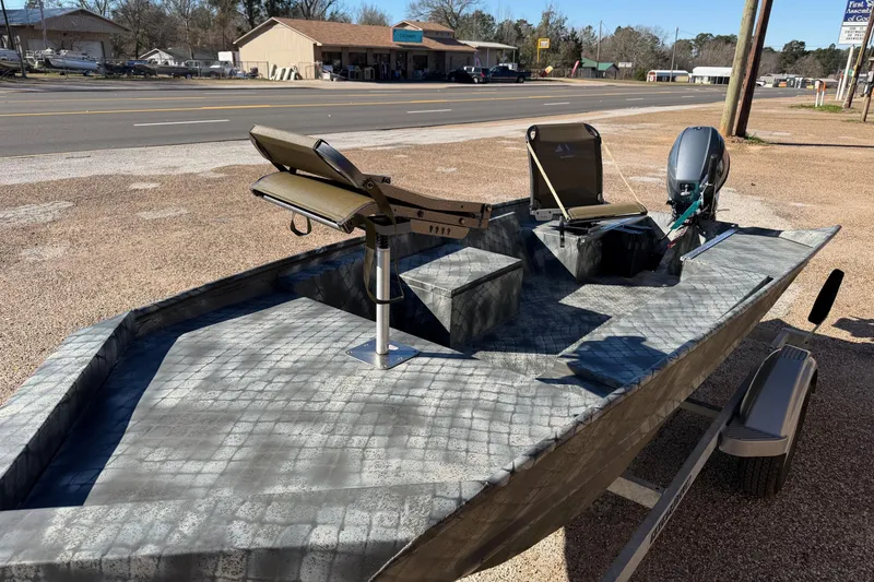Slide: The Image of 2025 WeldBilt 1448 boat with camouflage design, parked on a trailer near a road. - 3