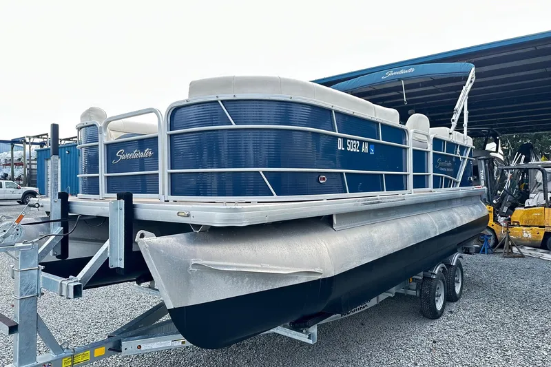 Slide: The Image of 2015 Godfrey 2286 Sweetwater Pontoon boat on trailer, blue and white design. - 1