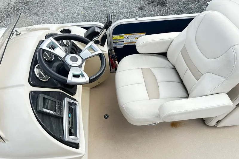 Slide: The Image of 2015 Godfrey 2286 Sweetwater Pontoon helm with steering wheel and comfortable captain's chair. - 3