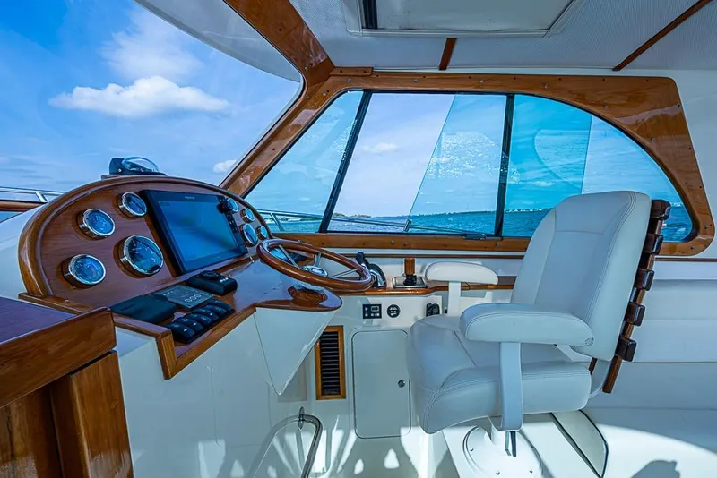 Slide: The Image of Interior helm of 2016 Hinckley Talaria 34 yacht with wooden dashboard and white captain's chair. - 10