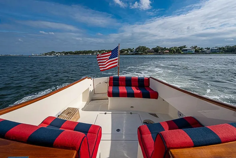 Slide: The Image of Hinckley Talaria 34 boat, 2016 model, with American flag and striped seating on open water. - 5