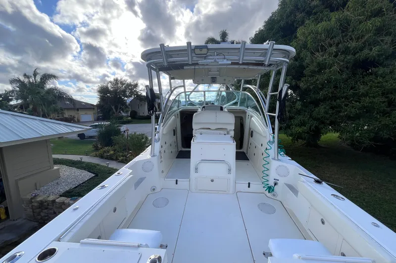 Slide: The Image of 2010 World Cat 290 EC boat with spacious deck and canopy, parked outdoors. - 10