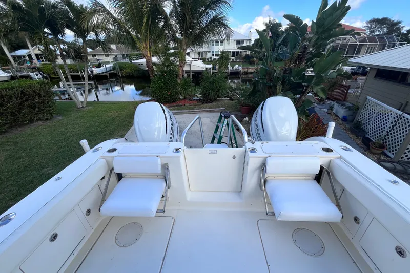 Slide: The Image of 2010 World Cat 290 EC boat with dual engines, docked near lush tropical surroundings. - 12