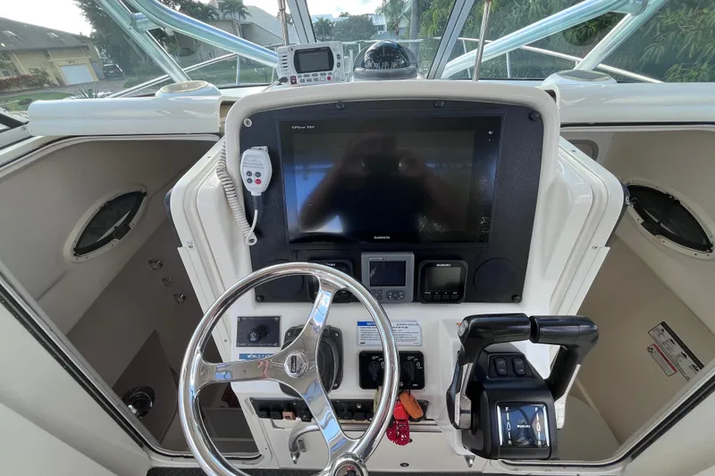 Slide: The Image of 2010 World Cat 290 EC helm with steering wheel, controls, and navigation display. - 19