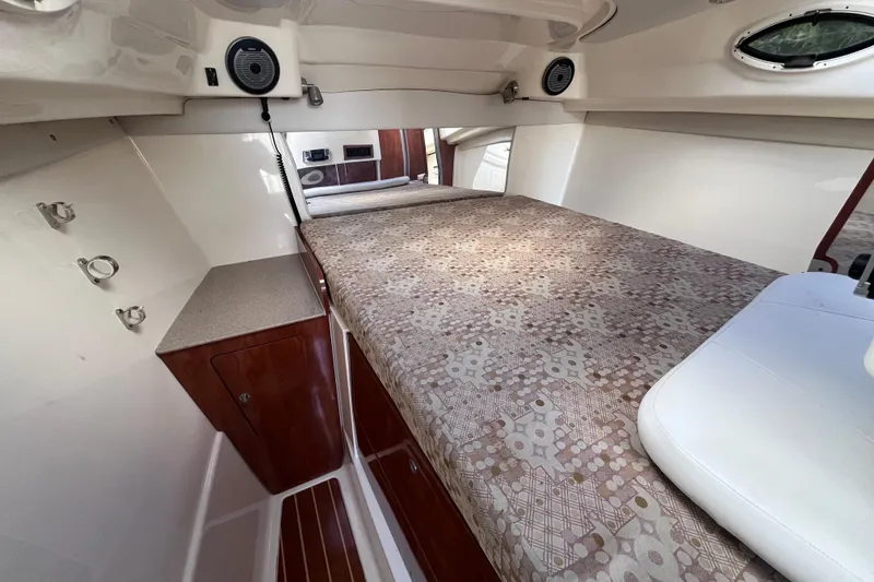 Slide: The Image of 2010 World Cat 290 EC cabin interior with patterned bedding and wooden cabinetry. - 23