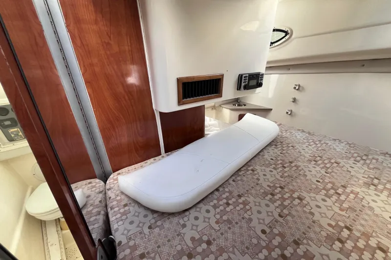 Slide: The Image of 2010 World Cat 290 EC cabin interior with bed, wood paneling, and control panel. - 27