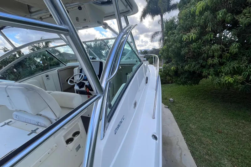 Slide: The Image of 2010 World Cat 290 EC boat, side view with cockpit and lush greenery background. - 32